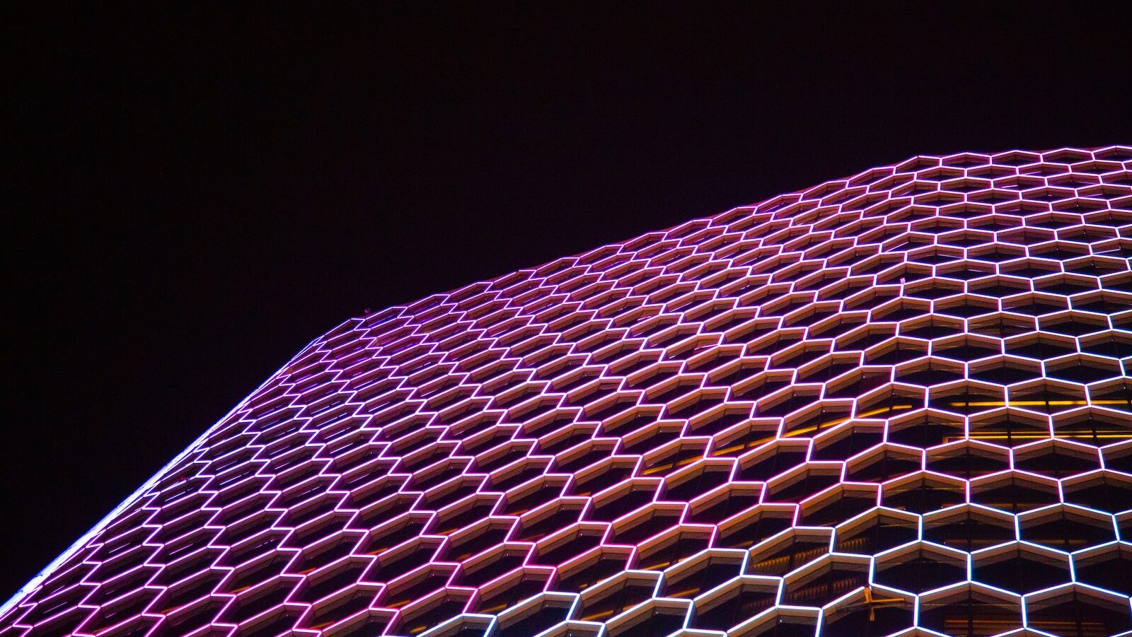 Decorative: The ICF Thought Leadership Institute's Futures Thinking Framework. Image description: a very tall building with a lot of hexagonal shapes on it